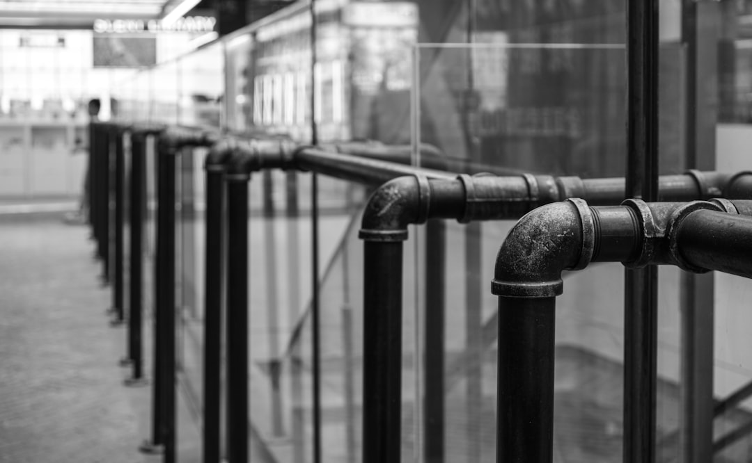 a-black-and-white-photo-of-a-metal-railing-1vvezkpwhvk
